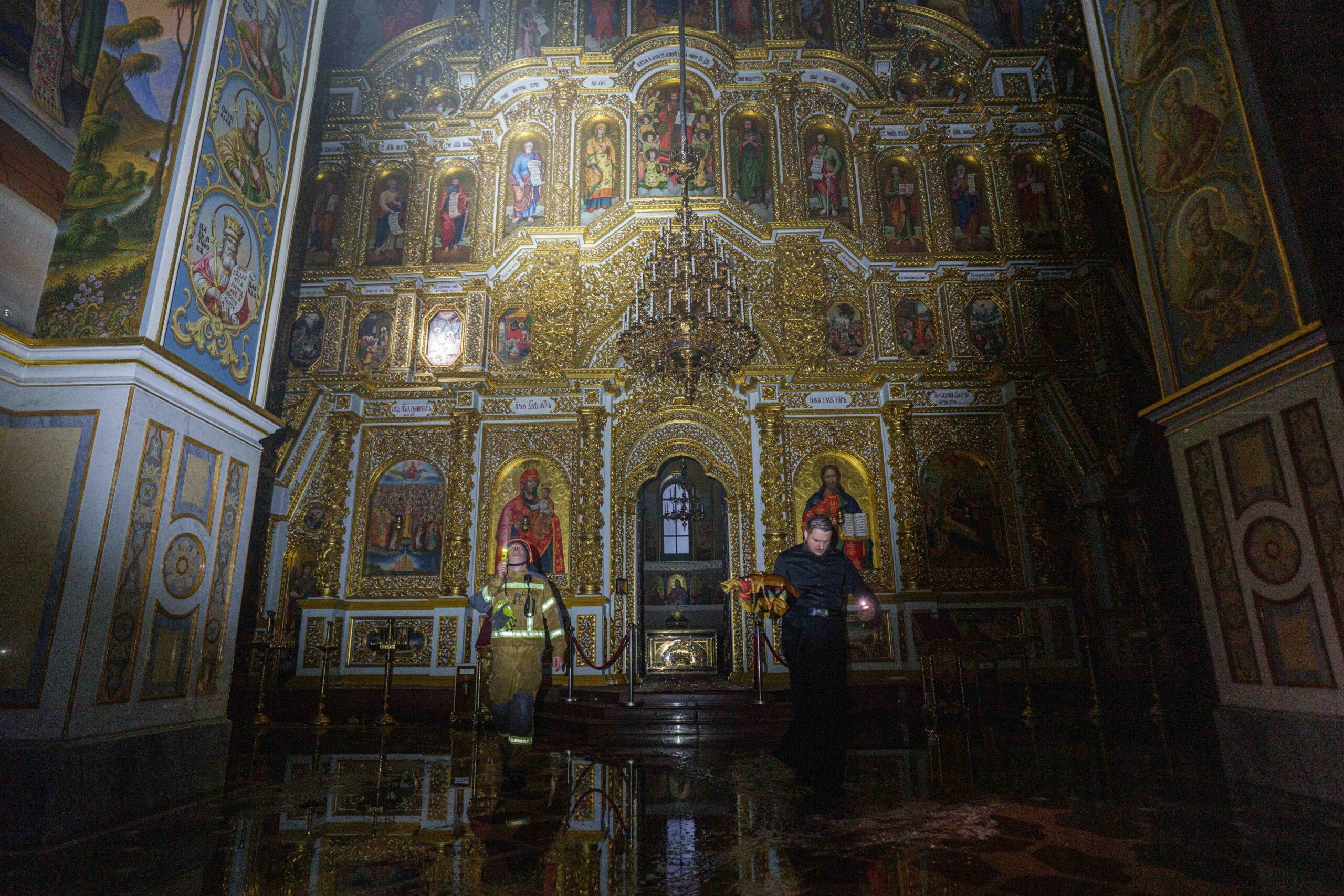 Kiew: Ein Priester trägt während eines russischen Angriffs auf Kiew Kirchengeräte aus der brennenden Mariä-Entschlafens-Kathedrale der Kiewer Höhlenkloster.