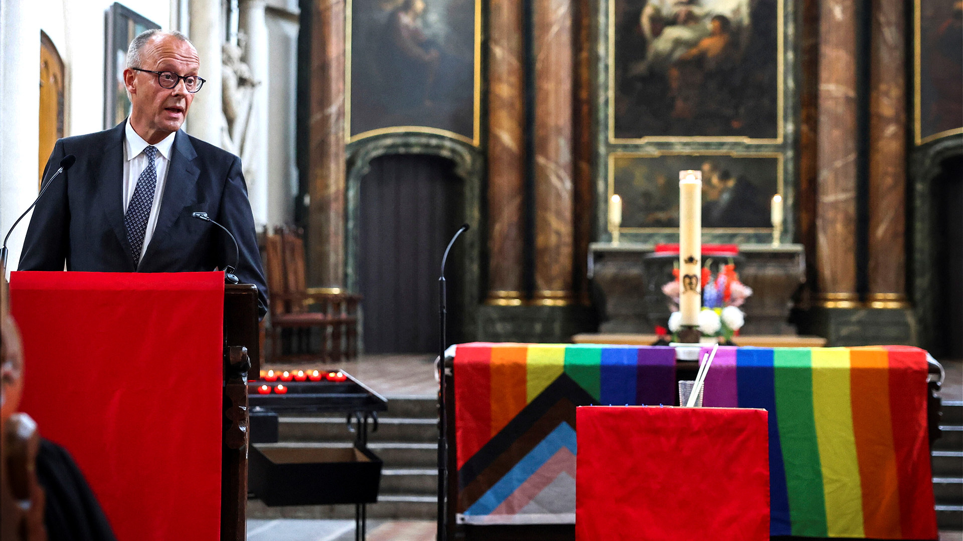 Bundeskanzler Friedrich Merz hielt neben einem Altar mit Progress-Pride-Fahne eine verstörende Rede.