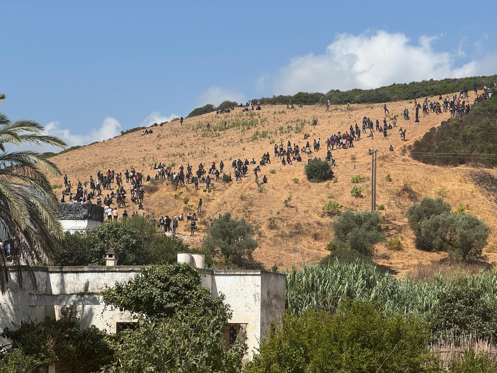 Die Migranten sammeln sich auf einem grenznahen Hügel.