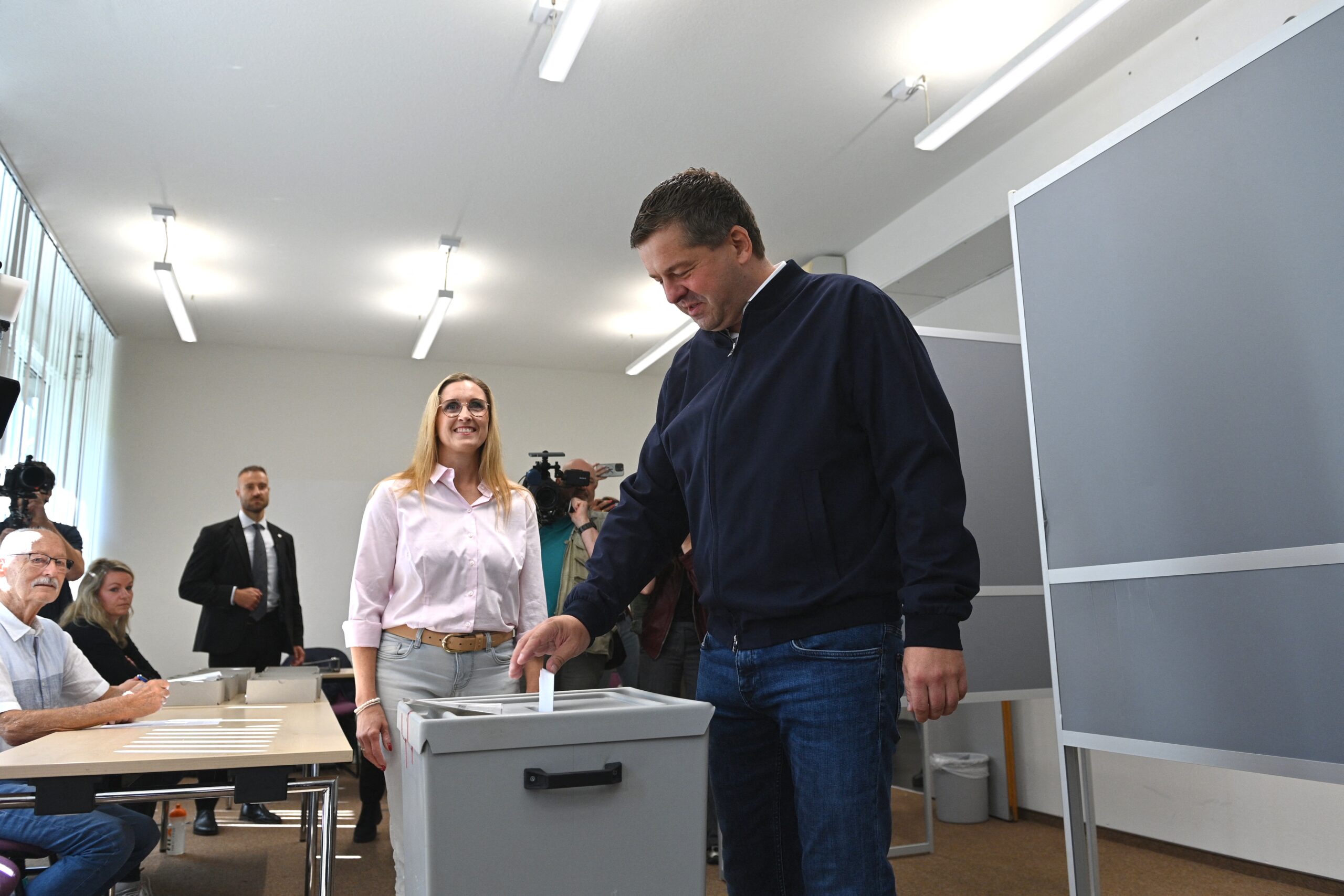 CDU-Ministerpräsident Sven Schulze wirft seinen gefalteten Stimmzettel in die Wahlurne. Hinter ihm steht seine Ehefrau Kati Schulze.